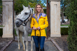 model with horse wearing yellow climate jacket and equestrian jeans